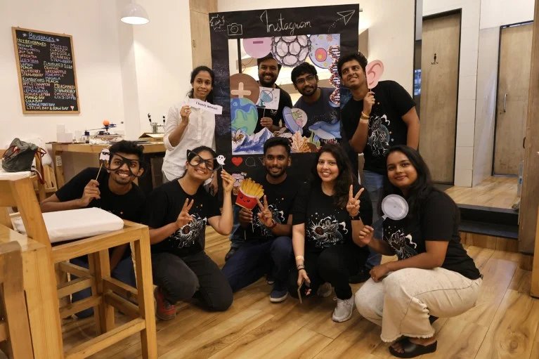 Debarati Chatterjee poses for a portrait with a group of smiling students at a science event